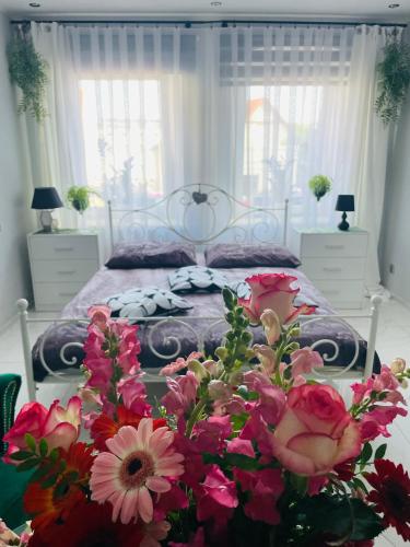 a bedroom with a bed with flowers in the foreground at Apartament u Danusi in Złoty Stok