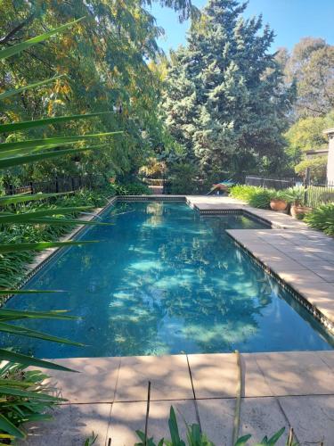 a swimming pool with blue water in a yard at Pool House in Albury