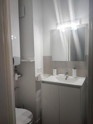 une salle de bain blanche avec un lavabo et des toilettes dans l'établissement studio cabine avec véranda et terrasse, à Luchon