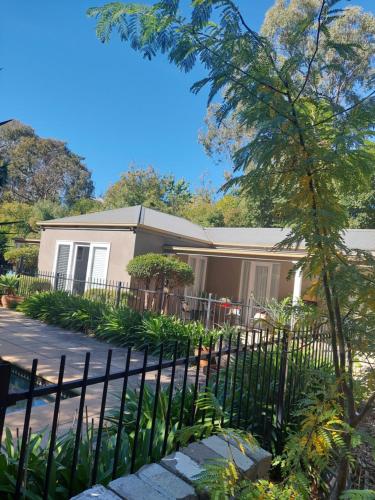a house with a fence in front of it at Pool House in Albury