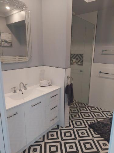 a bathroom with a sink and a mirror at Pool House in Albury
