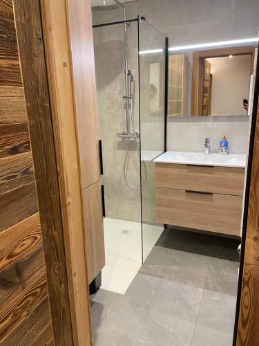 a bathroom with a glass shower and a sink at Chalet L'Alpaga in Châtel