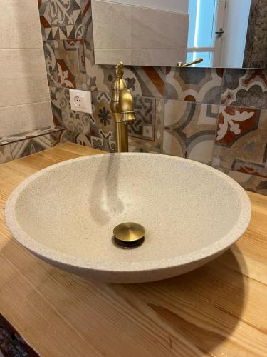 a white sink with a gold faucet on a table at B&B il gelsomino in Trarivi