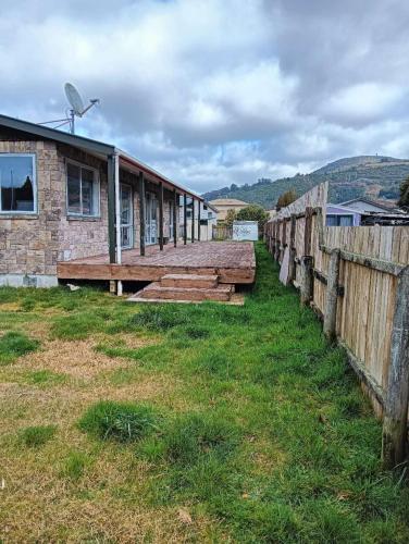a row of wooden benches in front of a building at 3 Bedroom House, 95 Aquirus Drive, Rotorua in Rotorua