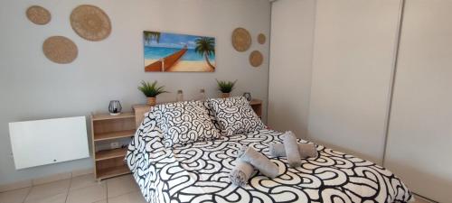 a bedroom with a bed with a black and white comforter at Superbe appartement en résidence avec piscine. in Albertville