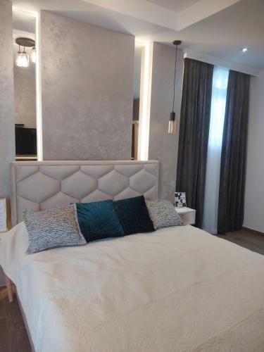 a bedroom with a large white bed with two pillows at Stan na dan PREMIUM 1 Obrenovac in Obrenovac