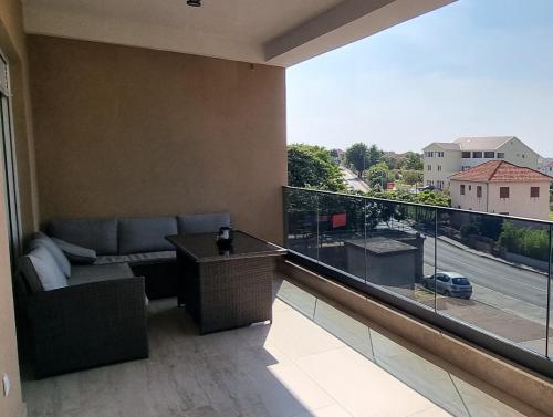 a balcony with a couch and a view of a street at Summer Park Residence Peljesac in Orebić