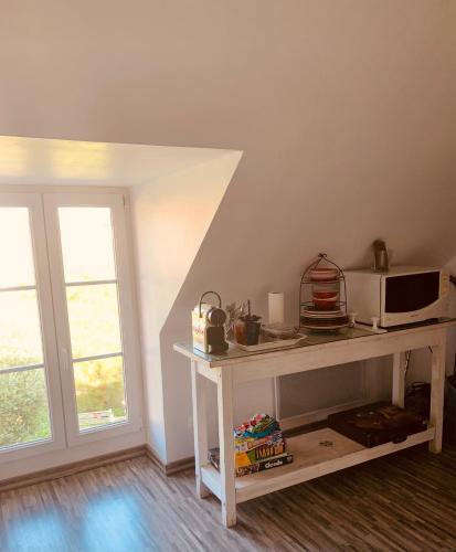 une chambre avec une table, un four micro-ondes et une fenêtre dans l'établissement CHAMBRE et JARDIN Village au bord de l eau Cour et Garage privés, à Marcilly-sur-Seine