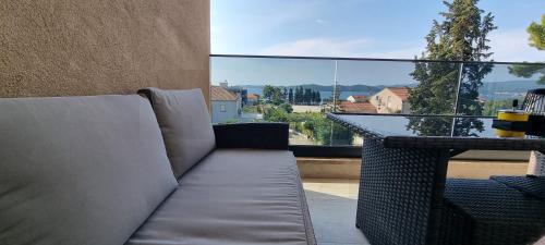 a couch sitting on a balcony with a view at Summer Park Residence Peljesac in Orebić