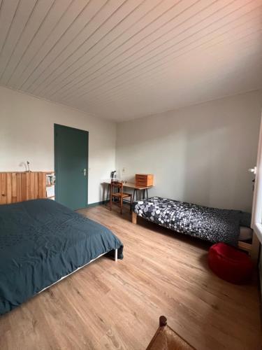 Un dormitorio con dos camas y un escritorio. en L’Albizia, en La Tranche-sur-Mer