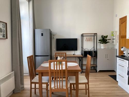 une cuisine avec une table, des chaises et un réfrigérateur dans l'établissement LocaNice Masséna, à Nice