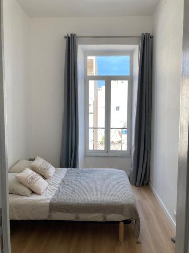 - une chambre avec un lit en face d'une fenêtre dans l'établissement LocaNice Masséna, à Nice