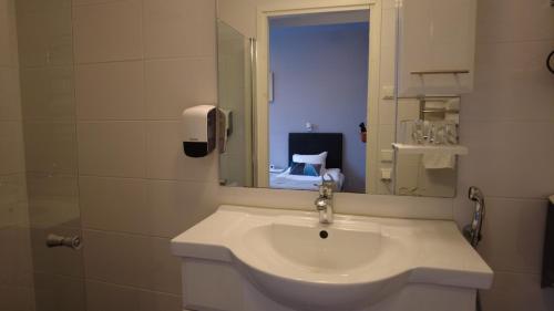a bathroom with a white sink and a mirror at Lapin Satu in Posio