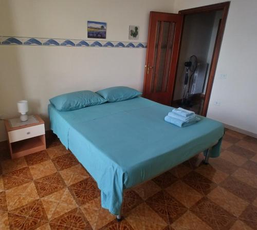 a bedroom with a bed with blue sheets and a door at Nunzia Home - Appartamento indipendente 85 mq - Bagno Privato - Aria Condizionata in Baiano