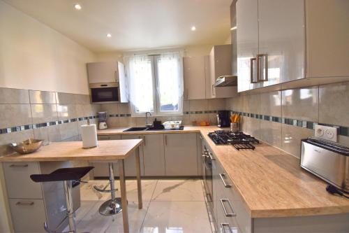 une cuisine avec un comptoir et une table à l'intérieur dans l'établissement L'Écrin de Goussainville, à Goussainville