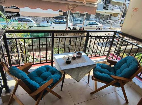 a balcony with a table and chairs on a balcony at Lovely maison house 50m from the beach at Nea Flogita in Flogita