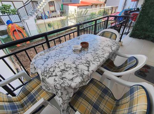 a table on a balcony with two cups on it at Lovely maison house 50m from the beach at Nea Flogita in Flogita