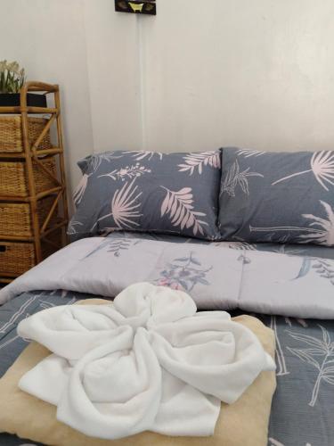a pile of towels sitting on top of a bed at Del Mar Transient House in Tarlac