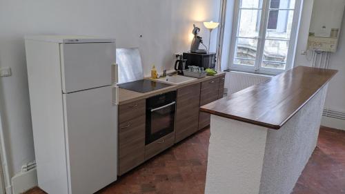 une cuisine avec un réfrigérateur blanc et un évier dans l'établissement Appartement Haussmannien 5 personnes ChapeauRouge Hôtel de ville Béziers centre historique coeur de l'Hérault capitale occitanie, à Béziers