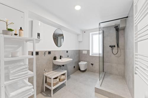 a white bathroom with a sink and a shower at TOP Apartments - Stilvolle Wohnung im Stadtzentrum - Loggia - Kingsize Bett - Smart TV - Netflix - 60qm - 24h Check-In in Ludwigsburg