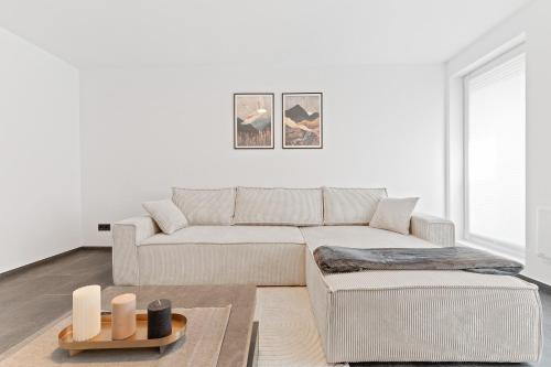 a living room with a couch and a table at TOP Apartments - Stilvolle Wohnung im Stadtzentrum - Loggia - Kingsize Bett - Smart TV - Netflix - 60qm - 24h Check-In in Ludwigsburg