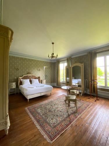 1 dormitorio grande con 1 cama y 1 mesa en Château de Luzières, en Conty