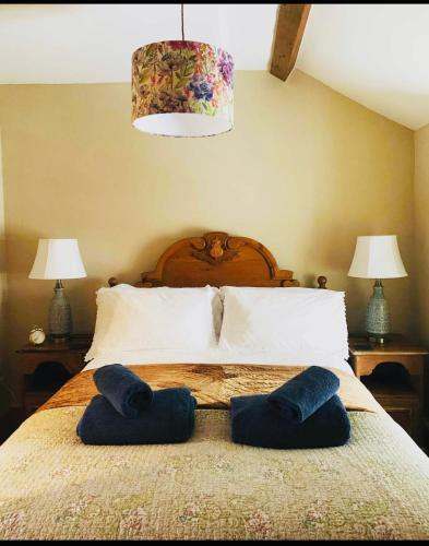 a bedroom with a bed with two blue pillows on it at Copper Miner’s Cottage in Beddgelert