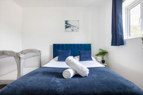 a bedroom with a blue and white bed with a towel on it at City Gem - 2 Bed House, 6 mins from Liverpool Street, Shops & Restaurants in London