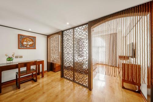 a room with a desk and a wall with a window at Cosy Feeling Hotel - Beijing Headquarters Xinfadi in Beijing