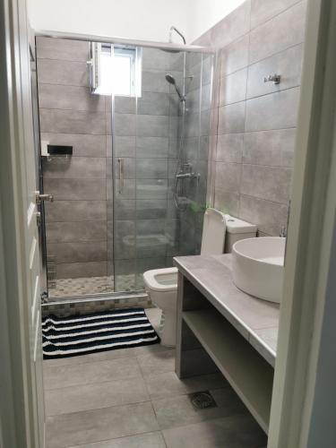 a bathroom with a shower and a toilet and a sink at Poros Askeli sea & mountain view apartment in Poros