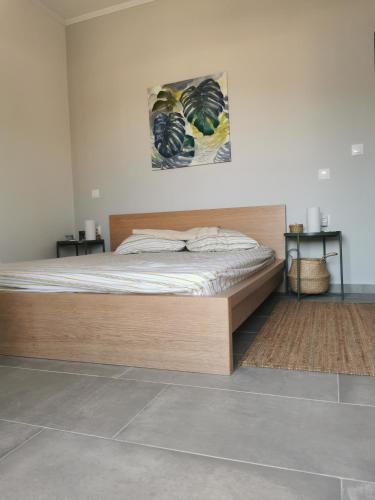 a bed with a wooden frame in a bedroom at Poros Askeli sea & mountain view apartment in Poros