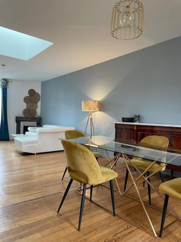 a living room with a glass table and chairs at CHTX Hôtel particulier Albert Ier in Châteauroux
