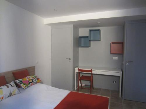 une chambre avec un lit, un bureau et une chaise dans l'établissement T2 refait à neuf avec petit jardin et parking, à Millau