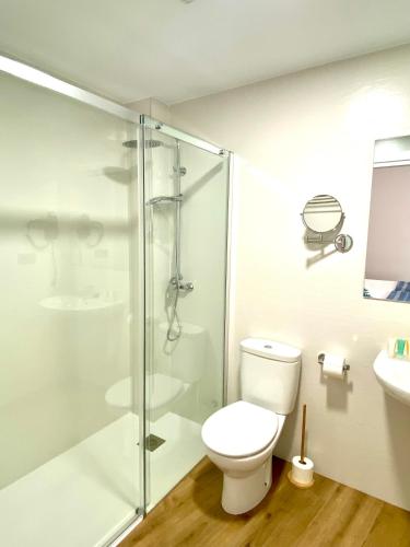 a bathroom with a toilet and a glass shower at El Rincón de Serradilla in Serradilla
