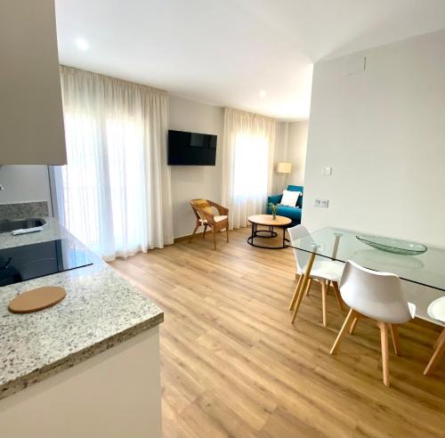 a kitchen and living room with a glass table and chairs at El Rincón de Serradilla in Serradilla