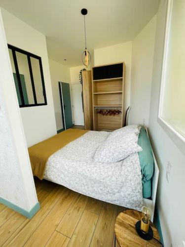 une chambre avec un lit et un parquet dans l'établissement Studio Ô terrasses de Virieu, à Pélussin