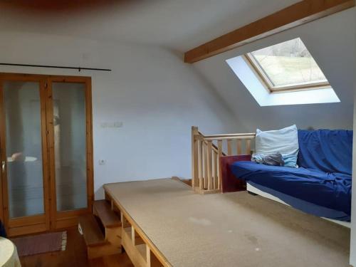 - un salon avec un canapé bleu et une lucarne dans l'établissement Maison verte à la montagne, à Saint-Alban