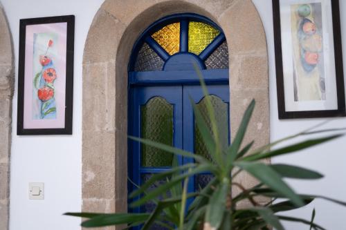 a blue door in a building with paintings at Riad Dar Afram in Essaouira