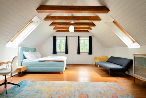 a bedroom with a bed and a couch and a tv at Landhaus Pößnitz in Leutschach