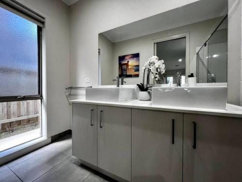 a bathroom with two sinks and a large window at five-room house next to the park16 in Altona Meadows