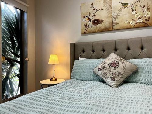 a bedroom with a bed with a pillow and a lamp at five-room house next to the park16 in Altona Meadows