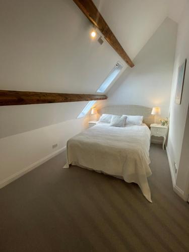 a bedroom with a white bed in a attic at Cosy flat in Ampney Crucis in Ampney Crucis
