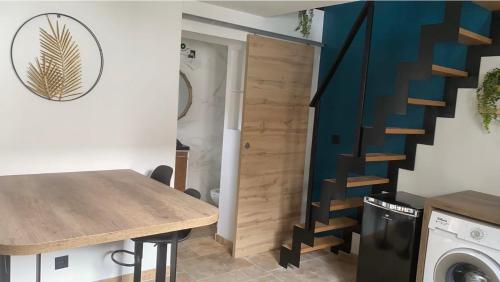 une cuisine avec une table en bois et un escalier dans l'établissement Logement, à Calais