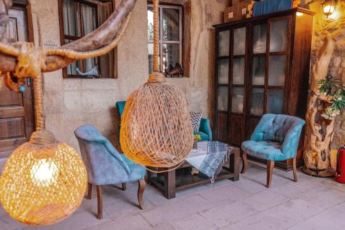 a patio with chairs and a table and a vase at Tafana Cave & Stone Lodge in Urgup