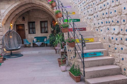 a stone building with stairs and potted plants at Tafana Cave & Stone Lodge in Urgup