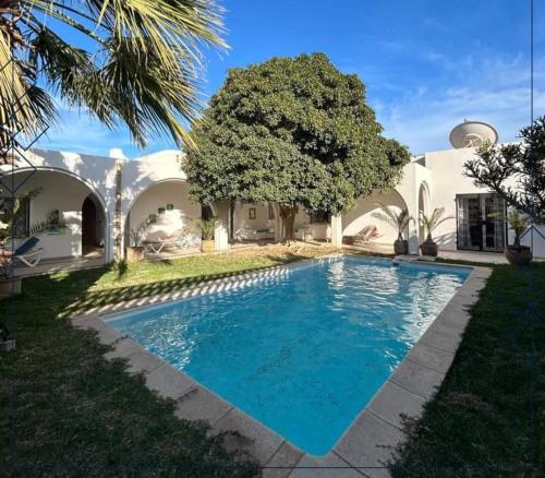 a swimming pool in front of a house at Esmeralda in Djerba