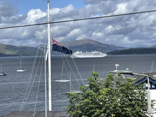 a cruise ship in the water with a british flag at Beautiful 3-Bed Apartment in Gourock in Gourock