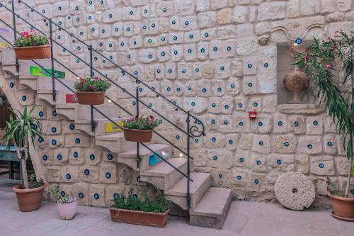 a stone wall with a staircase with potted plants at Tafana Cave & Stone Lodge in Urgup
