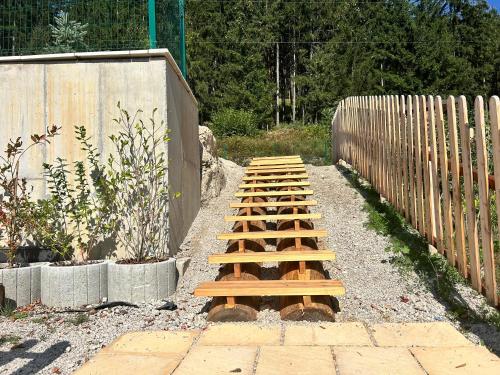 a wooden pathway in a garden with a fence at Horska Rezort in Ružomberok