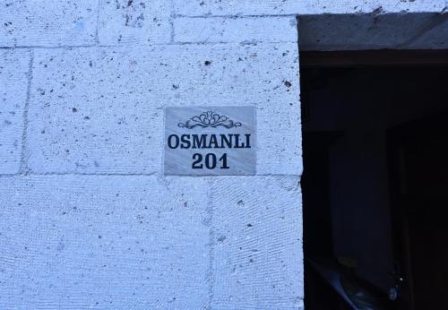 a sign on the side of a white brick building at Tafana Cave & Stone Lodge in Urgup